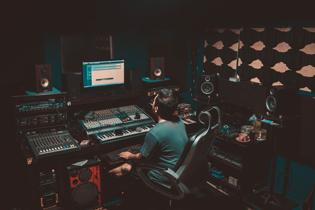 Professional voice over artist monitoring audio with headphones and studio monitors in recording studio